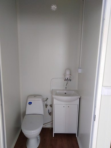 Chauffe-eau et WC compact intégrés dans un container bureau isolé.